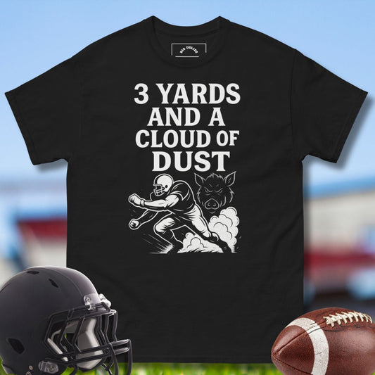 Black -shirt with football graphic and text, helmet, and football on a sports field background with the design 3 Yards and a Cloud of Dust by Big Ugliez