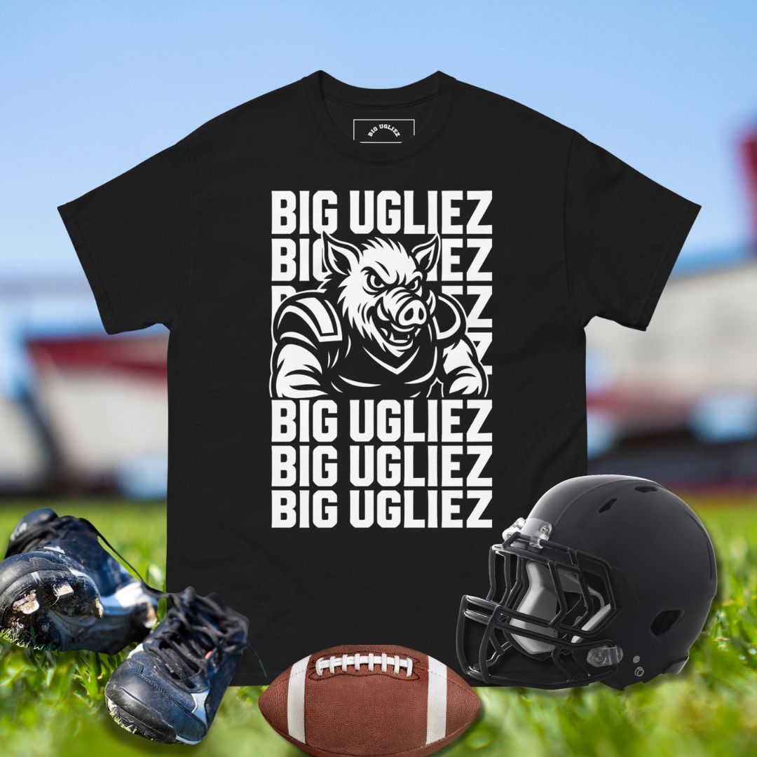 Black t-shirt with 'BIG UGLIEZ' graphic, football, helmet, and shoes on a sports field background