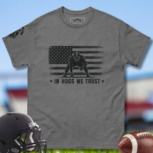 Gray t-shirt with American flag and football player graphic, helmet, and football on a sports-themed background.