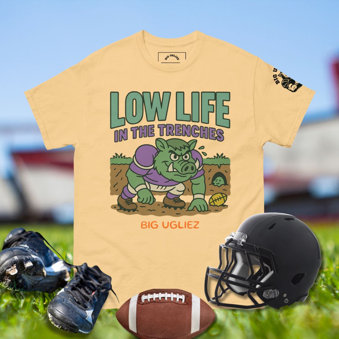 Yellow t-shirt with graphic design of a pig and text, black football helmet, cleats, and football on grass.