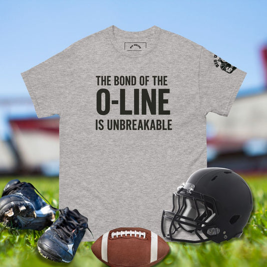 Gray t-shirt with 'The bond of the O-line is unbreakable' text, football, helmet, and cleats on a sports field background.