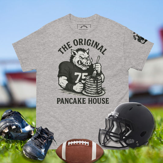 Gray t-shirt with graphic design of a cartoon boar and text 'The Original Pancake House' on a sports field background.