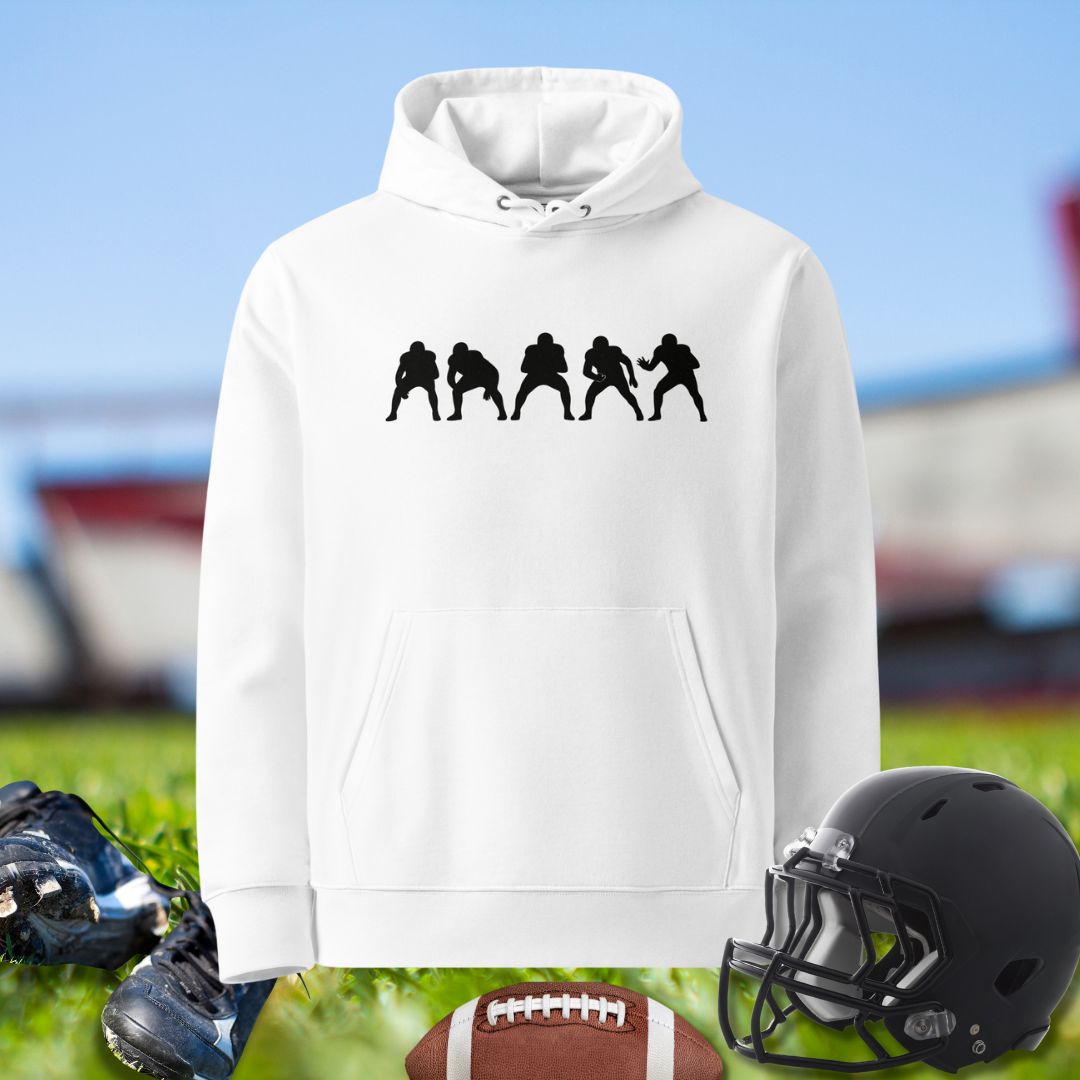 White hoodie with black silhouette design, football, cleats, and helmet on grass. Olinemen hoodie by Big Ugliez.