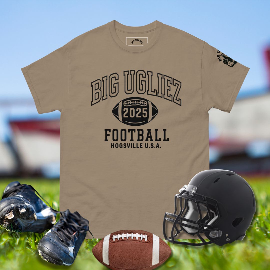 Beige t-shirt with 'BIG UGLIEZ 2025 FOOTBALL' text, black helmet, football, and cleats on grass.