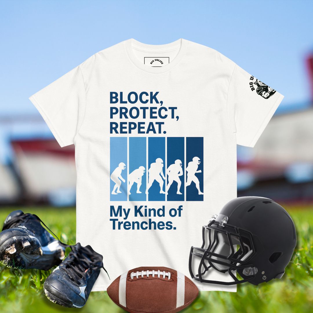 White t-shirt with football-themed design featuring text and graphics, displayed on a sports field background.