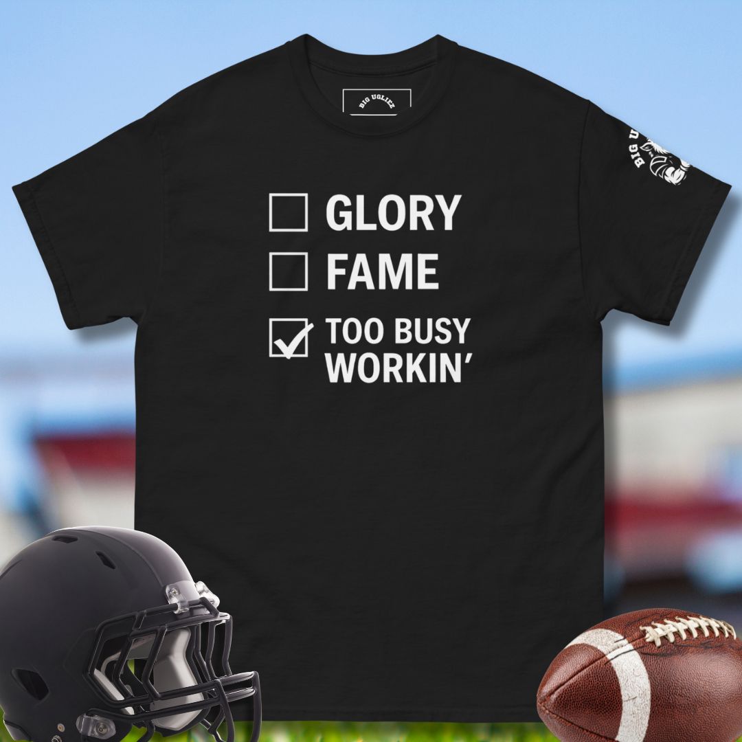 Black t-shirt with text 'GLORY, FAME, TOO BUSY WORKIN'' on a sports-themed background with helmet and football. For the football onlineman