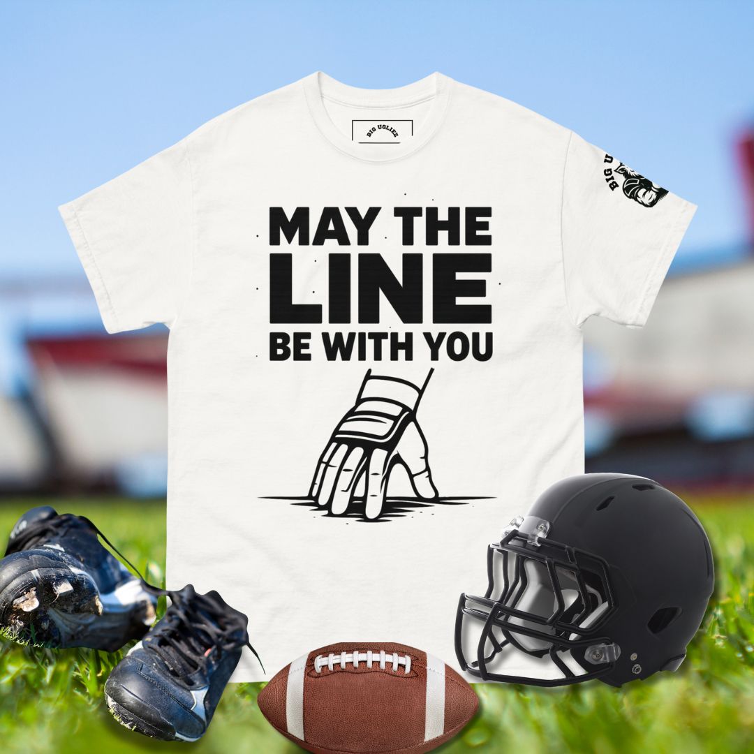 Football lineman hand in 3-point stance with taped wrist and glove under bold text May the Line Be With You in white tshirt