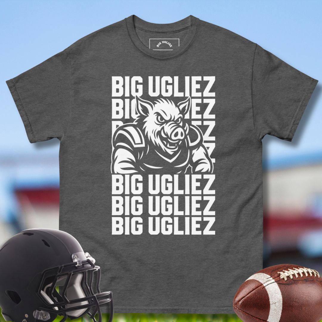 Gray t-shirt with 'BIG UGLIEZ' graphic and football helmet and ball on a sports field background