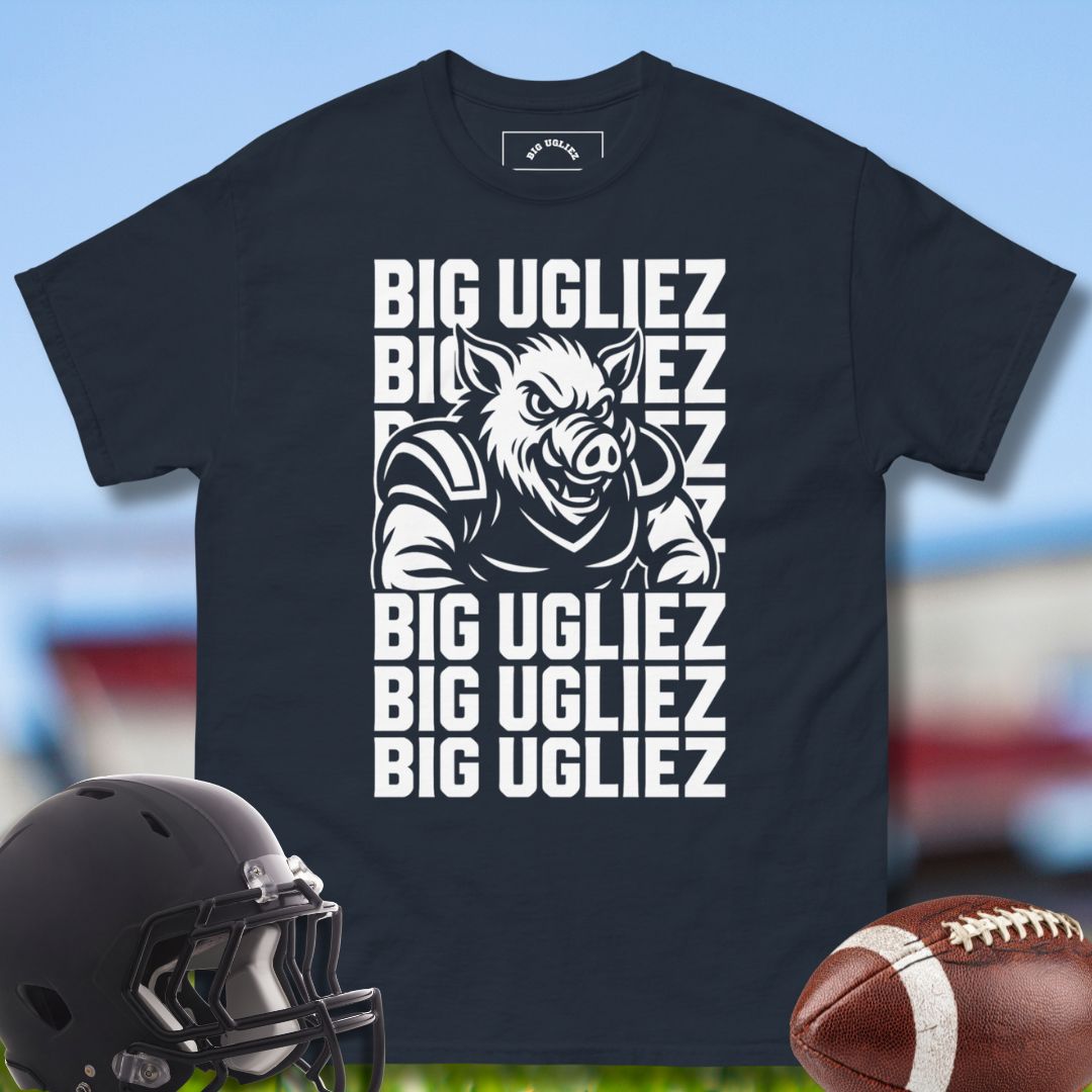 Navy t-shirt with graphic design and Big Ugliez text, helmet, and football on a sports field background