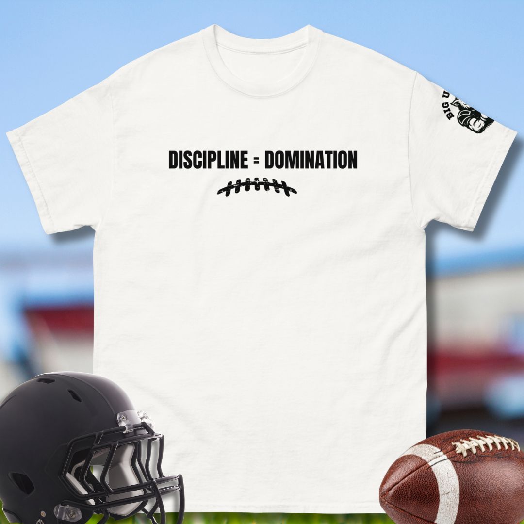 White t-shirt with 'Discipline = Domination' text, black helmet, and football on a sports field background