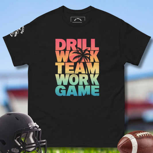 Black t-shirt with colorful text 'DRILL WORK TEAM WORK GAME' on a sports field background.