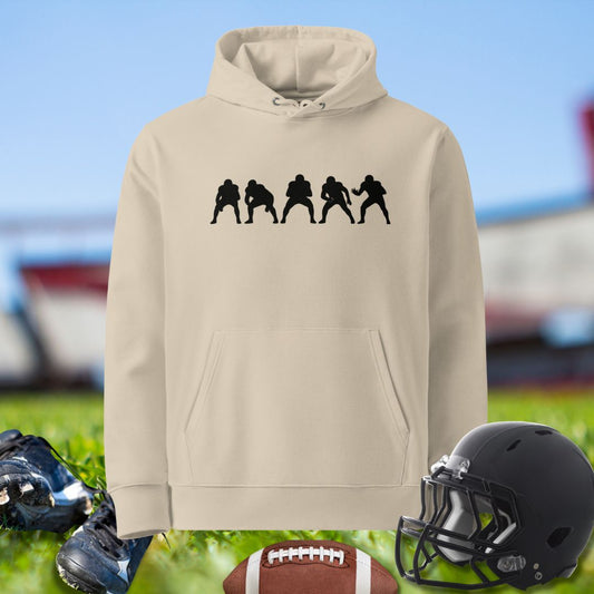Beige hoodie with black graphic, football, cleats, and helmet on grass background for Olinemen