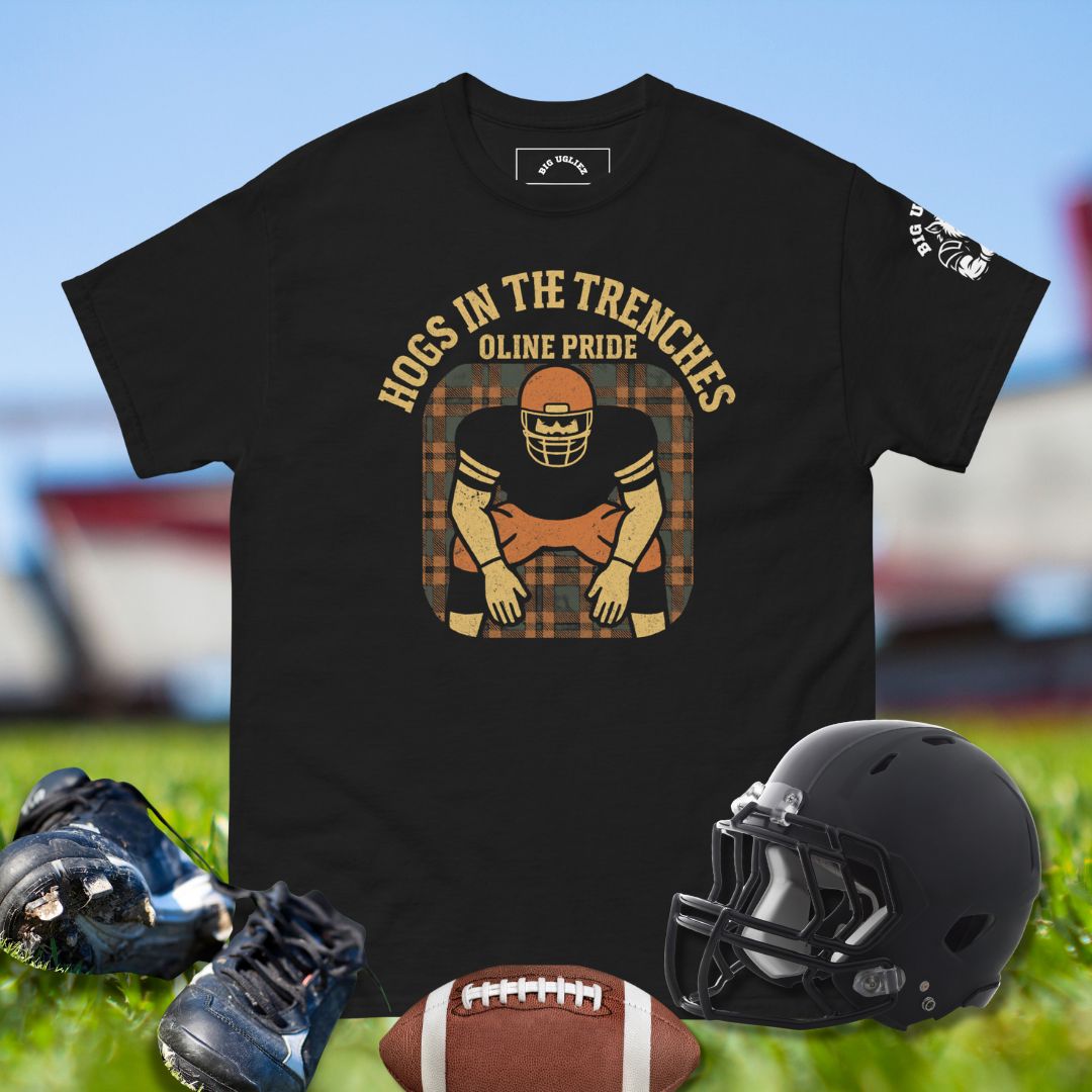 Black t-shirt with football-themed design featuring a helmet, shoes, and ball on grass.