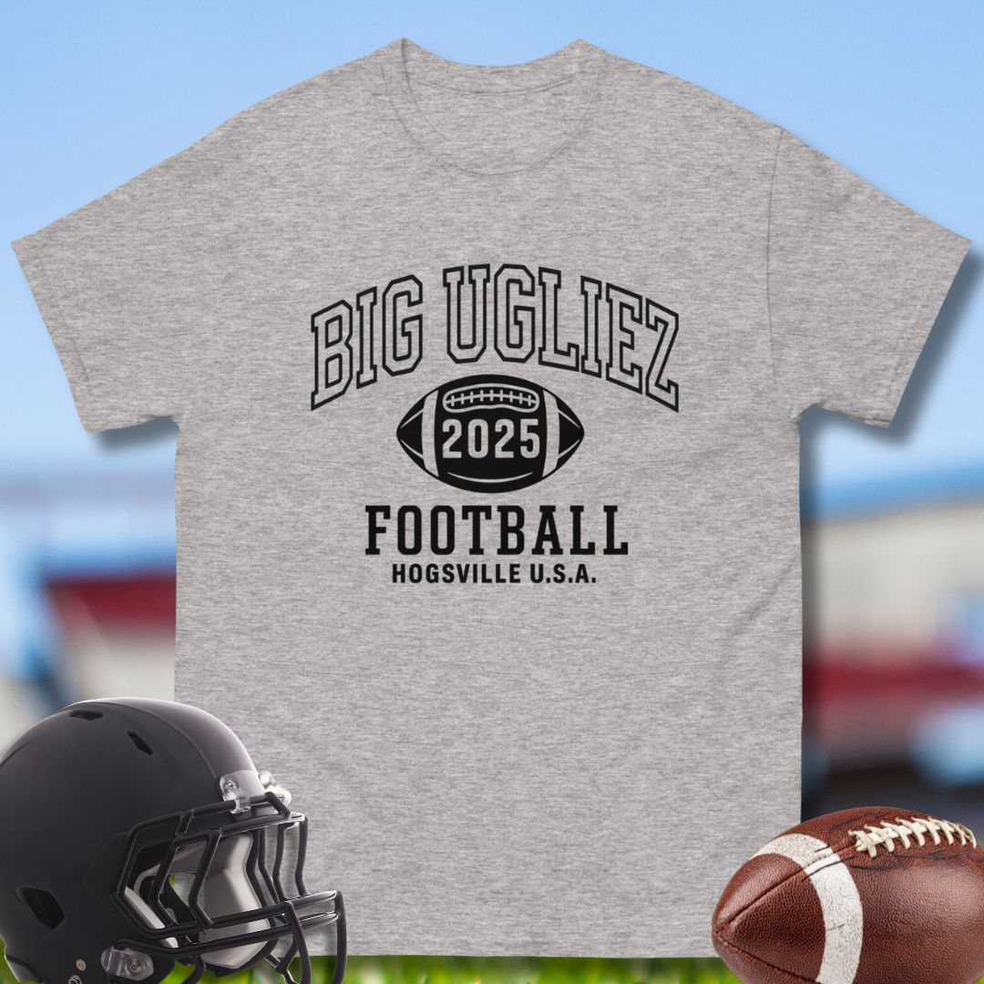 Gray t-shirt with 'BIG UGLIEZ 2025 FOOTBALL HOGSVILLE U.S.A.' text, black helmet, and football on a sports field background.