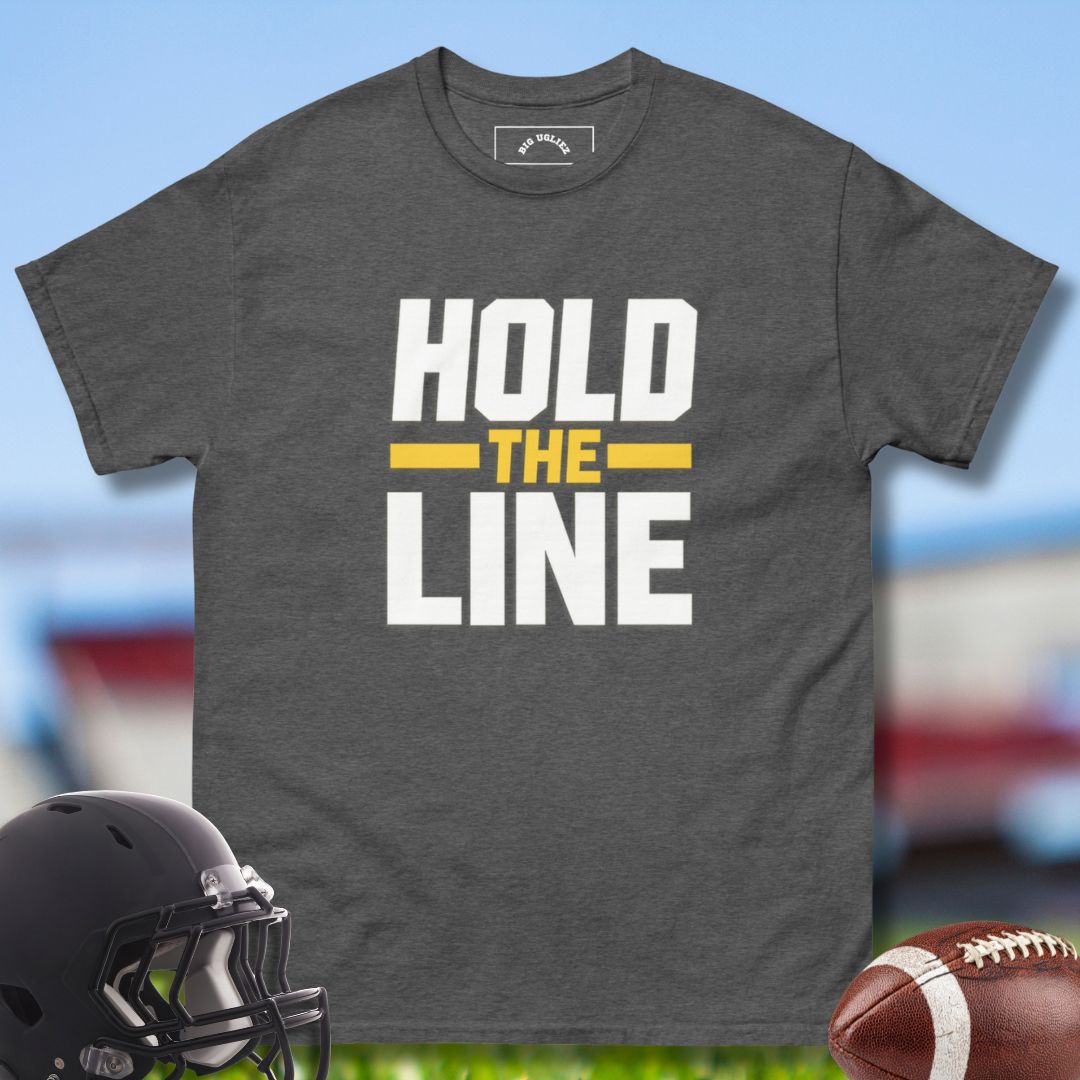 Gray t-shirt with 'Hold the Line' text, black helmet, and football on a sports field background