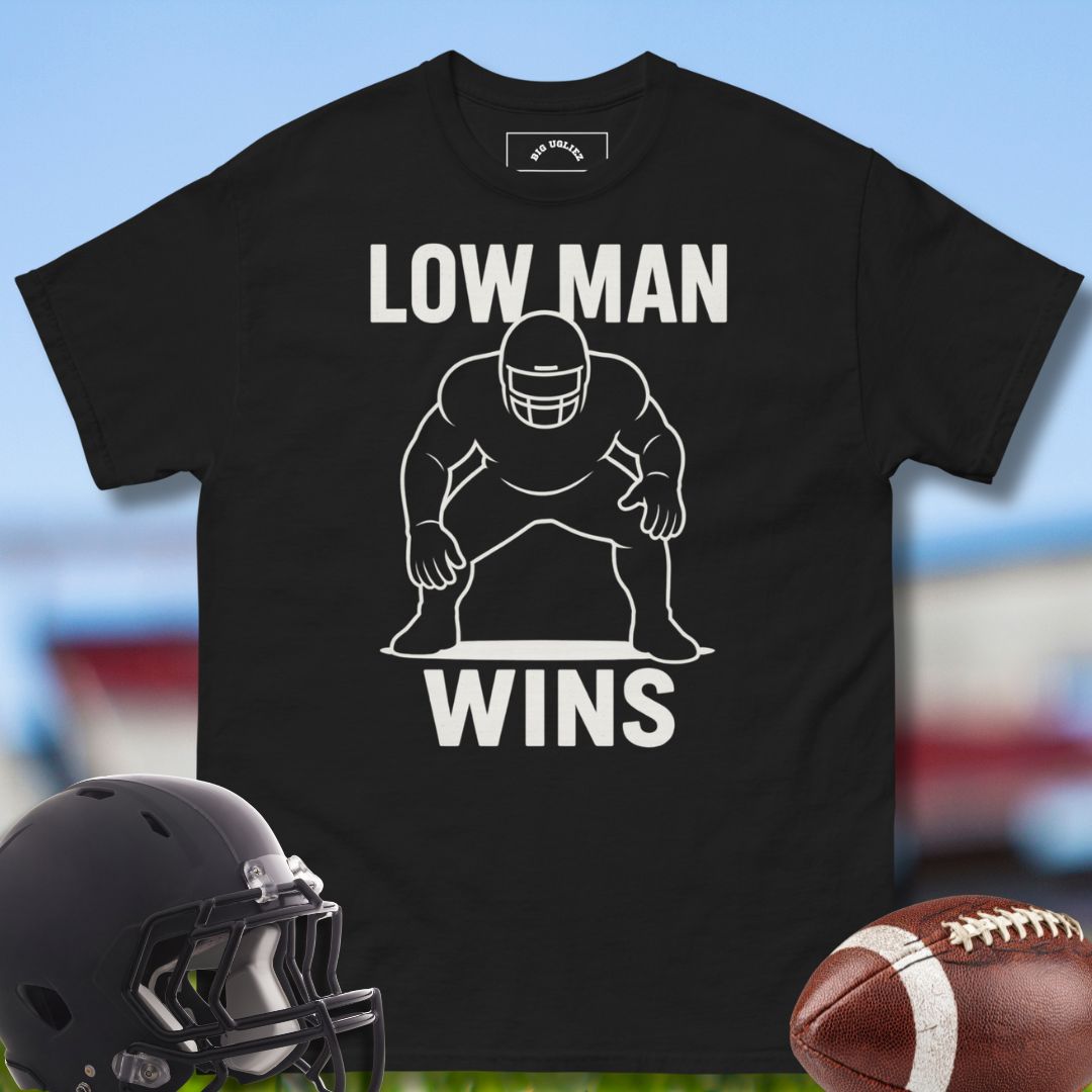 Black t-shirt with 'LOW MAN WINS' graphic, helmet, and football on a sports-themed background