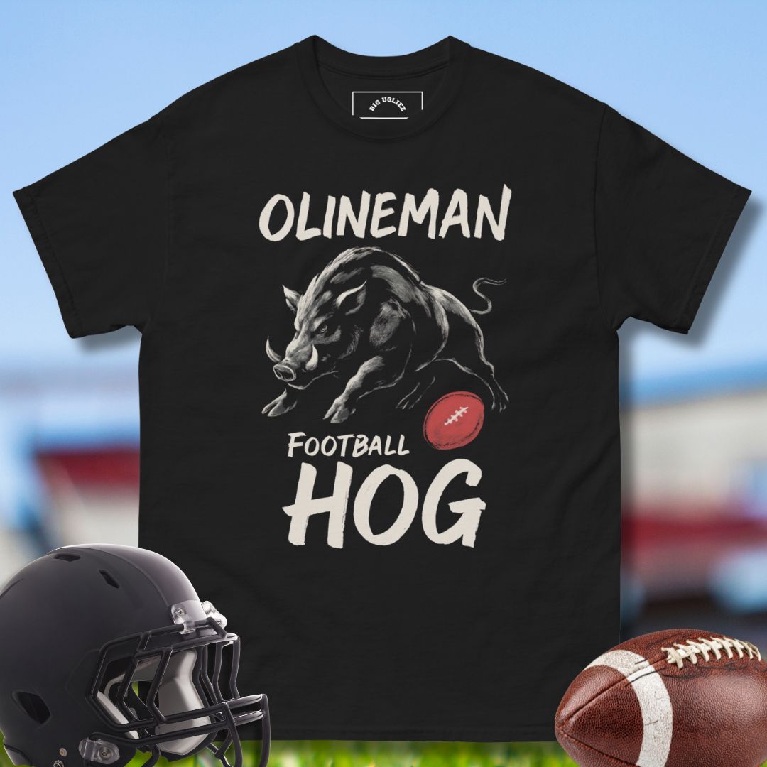 Black t-shirt with 'Olineman Football Hog' design, helmet, and football on a sports field background by Big Ugliez