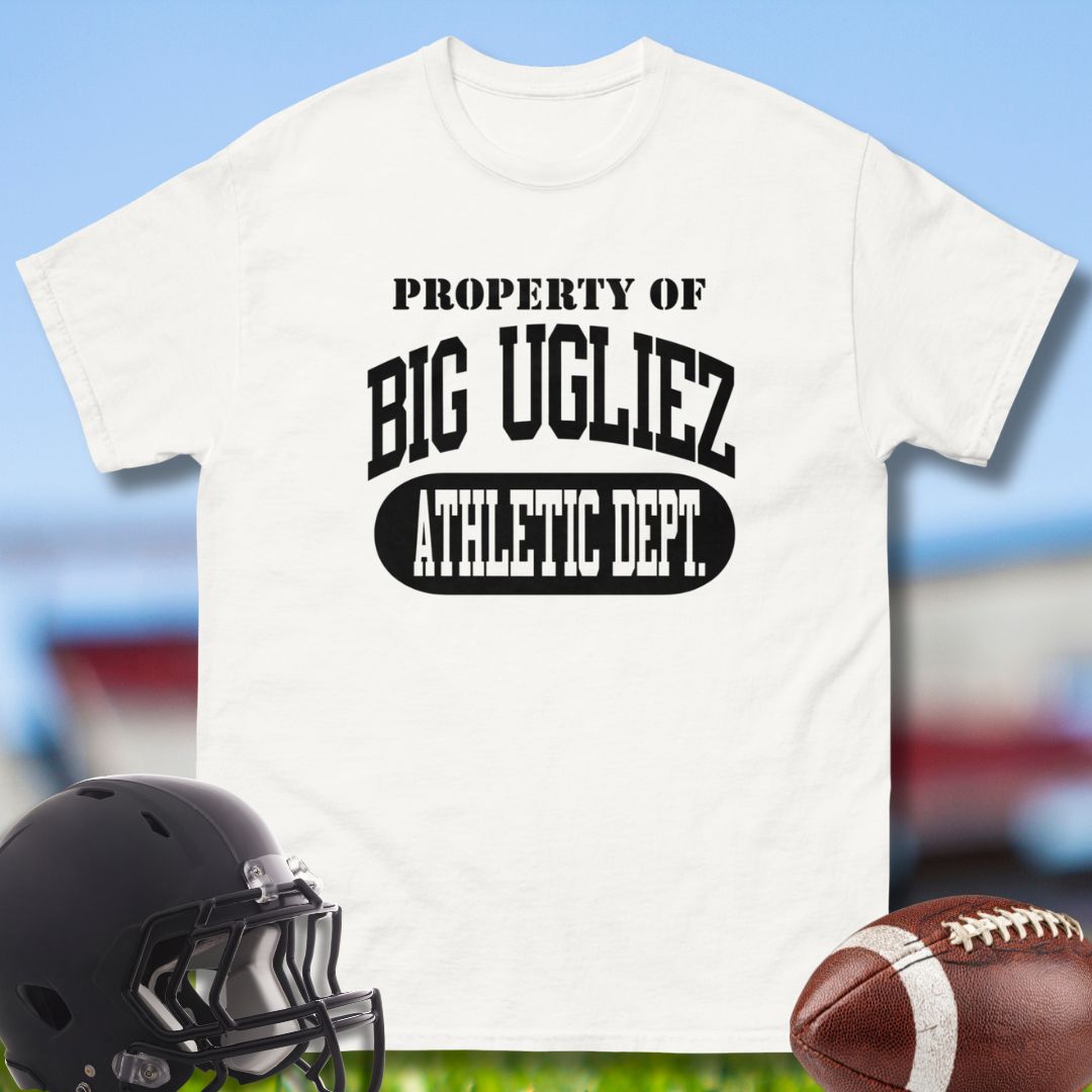 White t-shirt with 'PROPERTY OF BIG UGLIEZ ATHLETIC DEPT.' text, black helmet, and football on a sports field background.