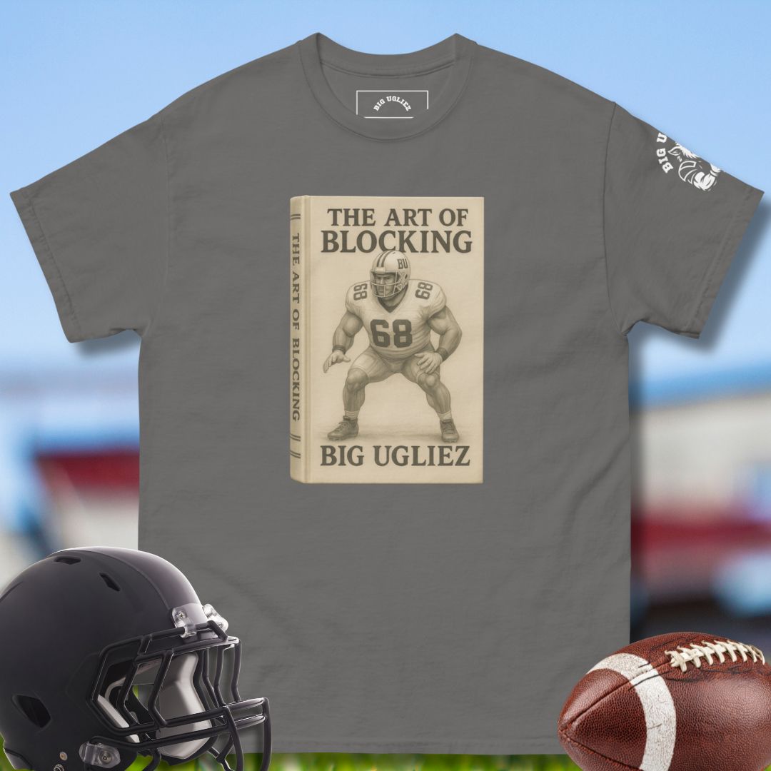 Gray t-shirt with 'The Art of Blocking' graphic, helmet, and football on a blurred sports background