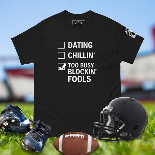 Black t-shirt with humorous text design on a sports field background